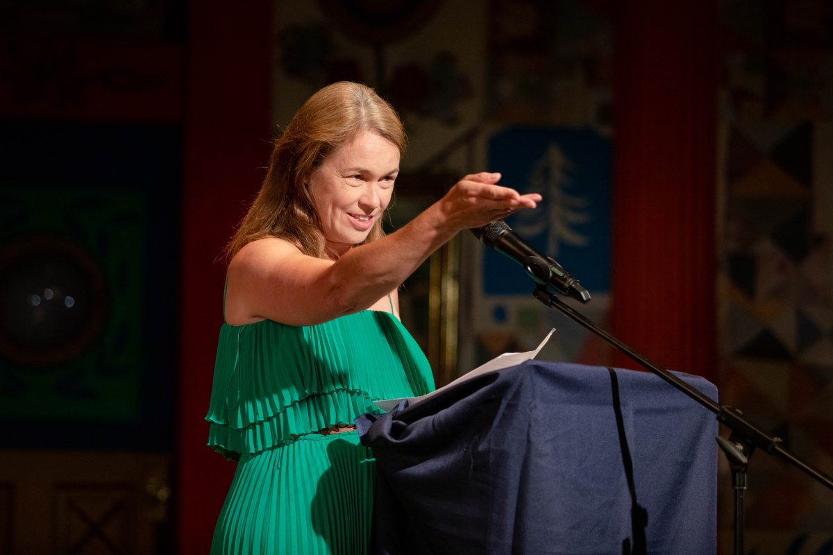 Lexi Rees on stage at an author event reading an extract