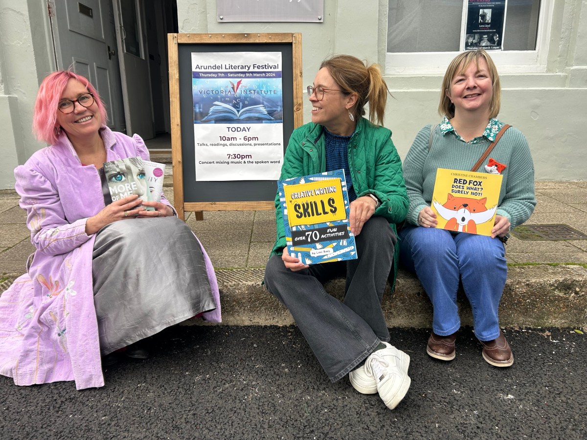 Lexi Rees holding activity books at Arundel Literary Festival